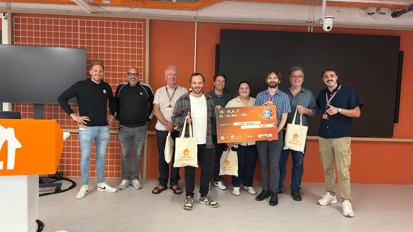 The winning team on stage with their prize board